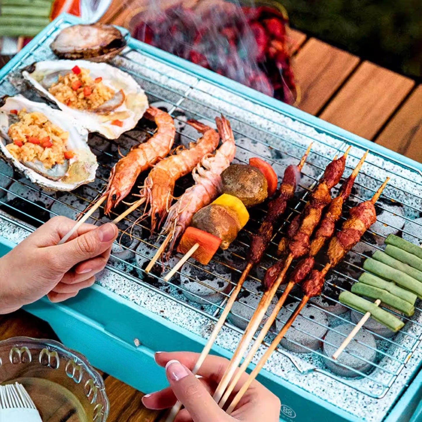 Grill with skewered food including shrimp, vegetables, and meats on a wooden table.